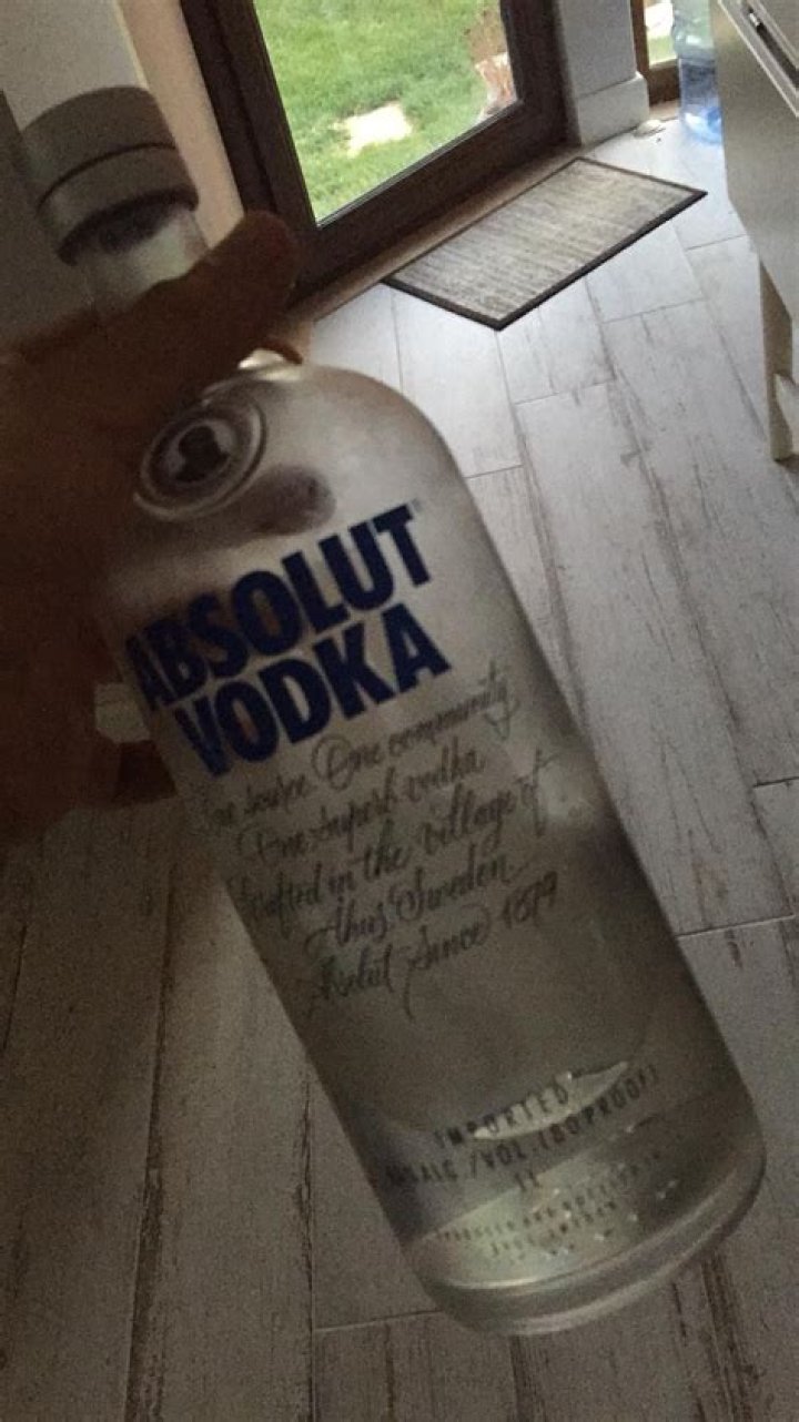 A vodka bottle held up to the light and then shaken.
