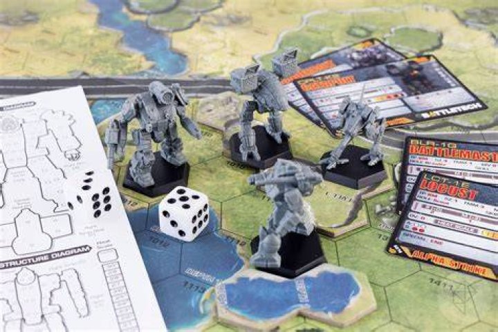 BattleTech miniatures, dice, and cards on a game board