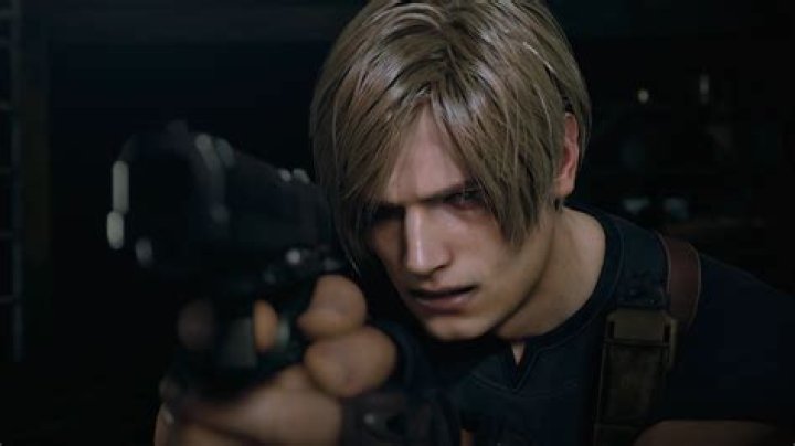 Leon S. Kennedy fires his handgun at encroaching zombie police officers in a dark hallway in Raccoon Police Station